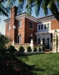 A traditional brick house with manicured landscaping and a sunny atmosphere.