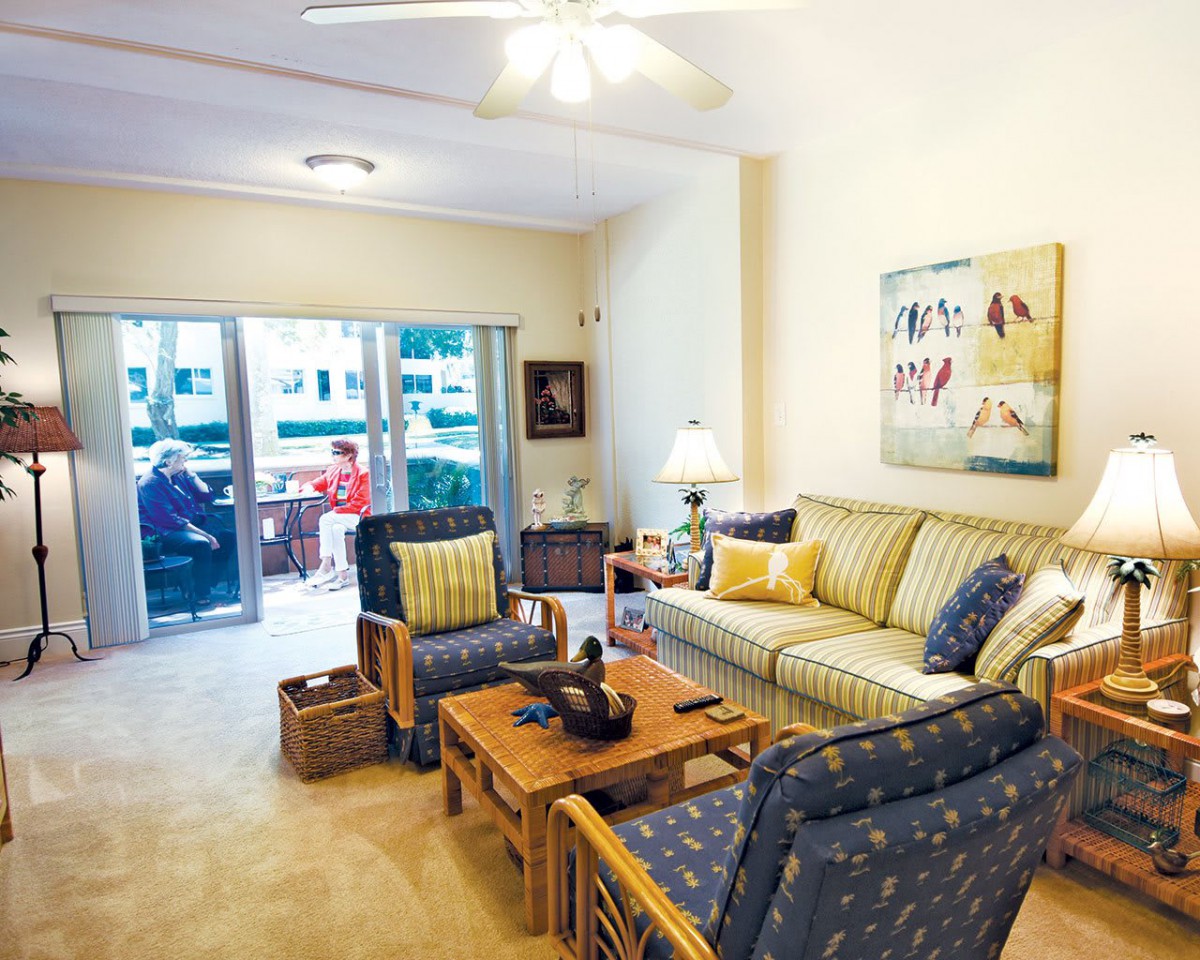 A cozy living room with comfortable seating and a view of the balcony.