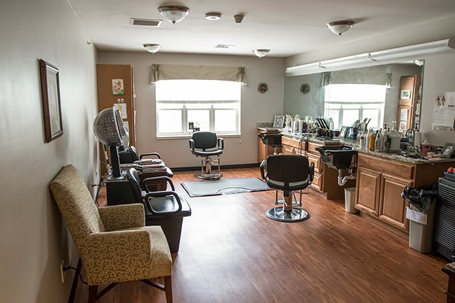 A cozy salon interior with chairs and hairdressing equipment.