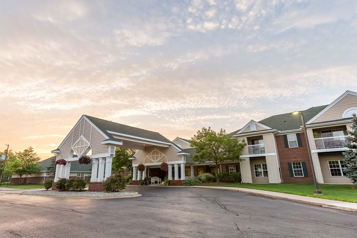 A residential building with a parking lot at sunset.