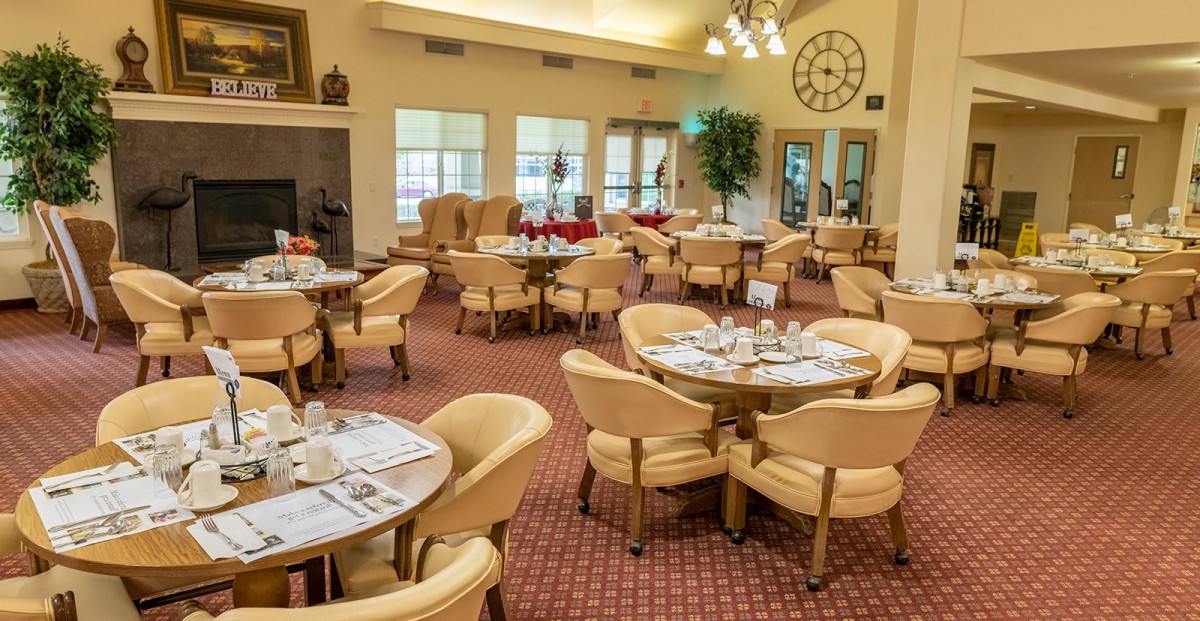 An elegant dining room with neatly arranged tables and chairs, featuring large windows and stylish decor.