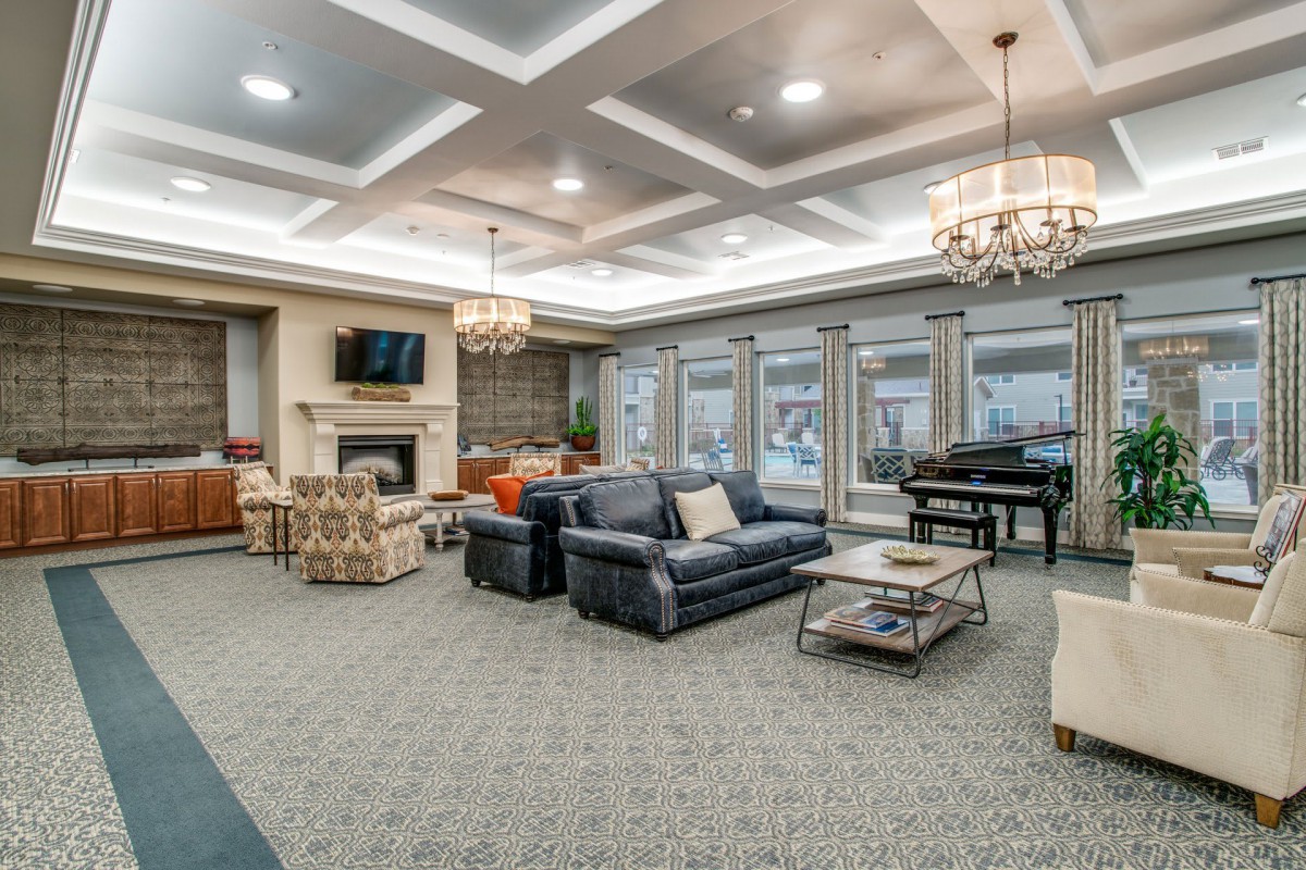 A spacious and elegantly designed living room with comfortable seating, a fireplace, and a piano.