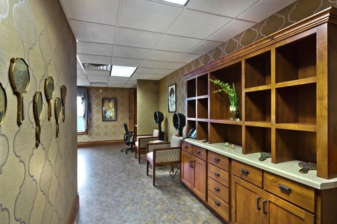 An office waiting area with desks, chairs, and decorative shelving.