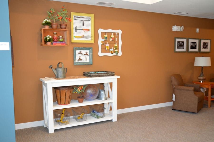 A cozy living space with a decorated wall and a console table displaying various items.