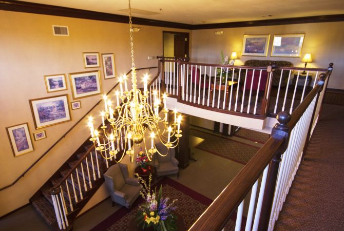 A beautifully lit interior space featuring a grand chandelier above a cozy seating area with elegant decor.