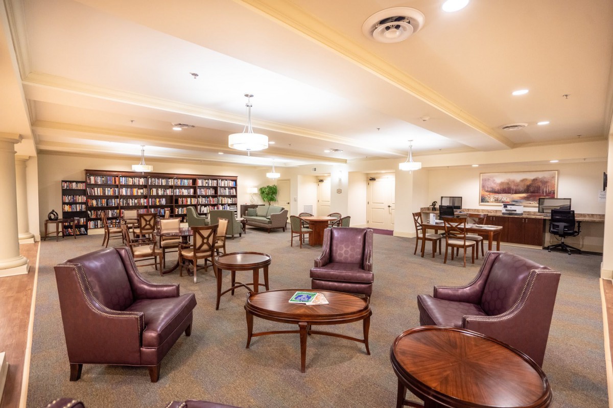 A cozy library interior with comfortable seating and rows of bookshelves.