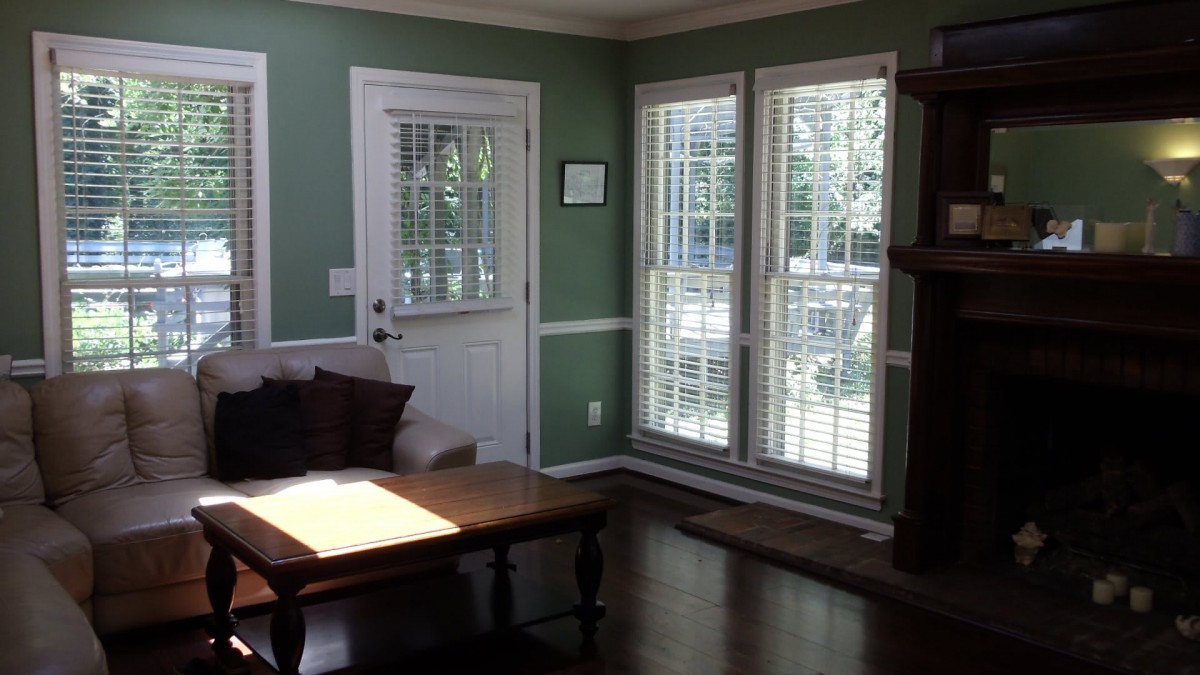 A cozy living room with large windows and a coffee table.