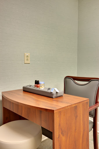 A simple workspace featuring a wooden desk and a chair, perfect for focused tasks.