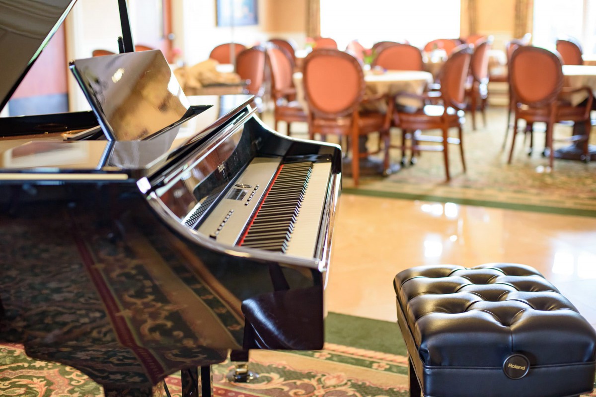 A grand piano in an elegant dining room setting.