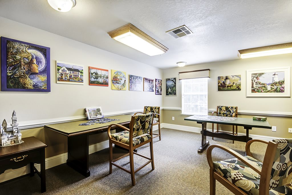 A well-lit meeting room with tables, chairs, and artwork on the walls.