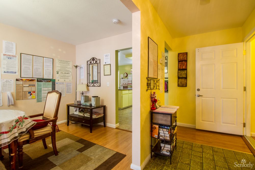 A cozy entryway and living area with yellow walls, featuring furniture and decor.