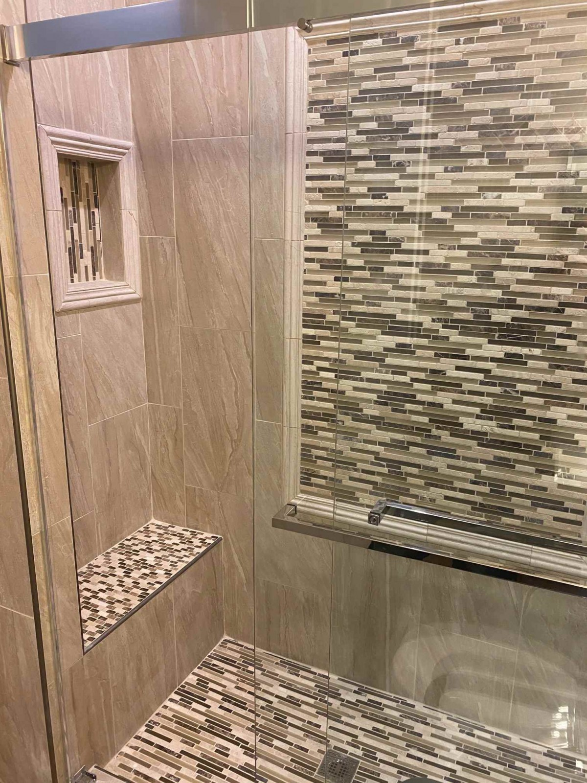 Modern bathroom featuring a shower with mosaic tile design.