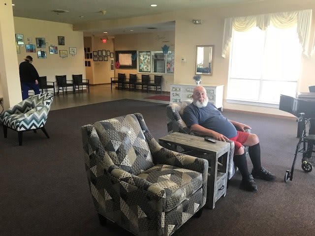 A person sitting in a chair in a well-lit living room.