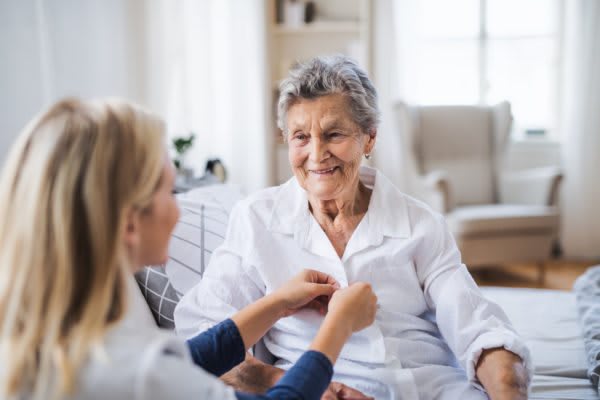 A caregiver assists an elderly woman at home, showcasing compassion and support.