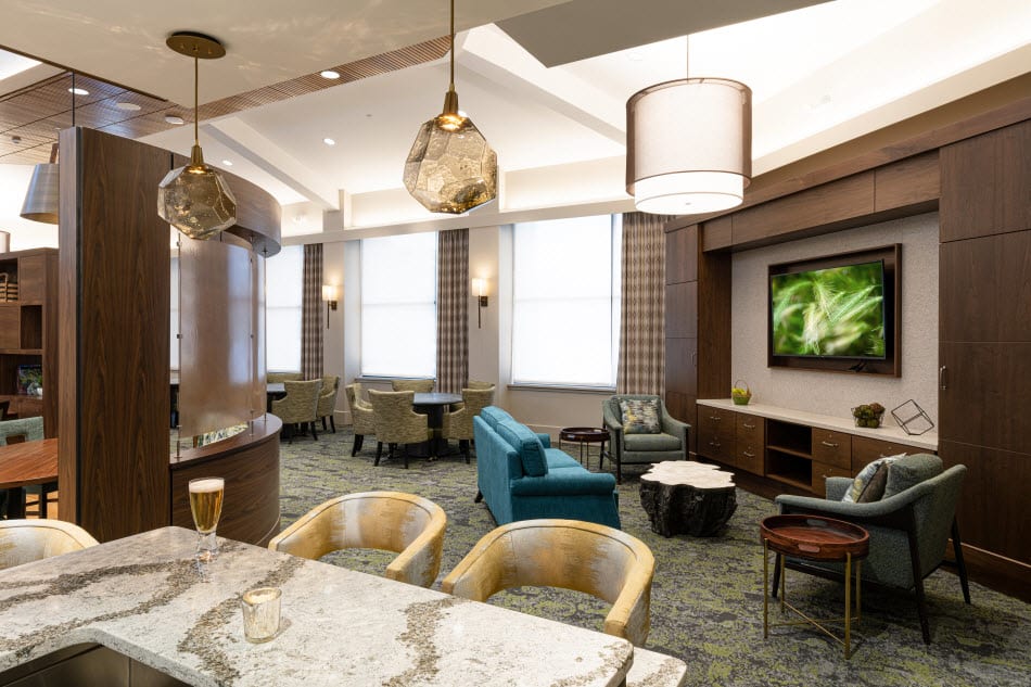 A modern lounge area featuring stylish furniture, elegant lighting, and a bar counter.
