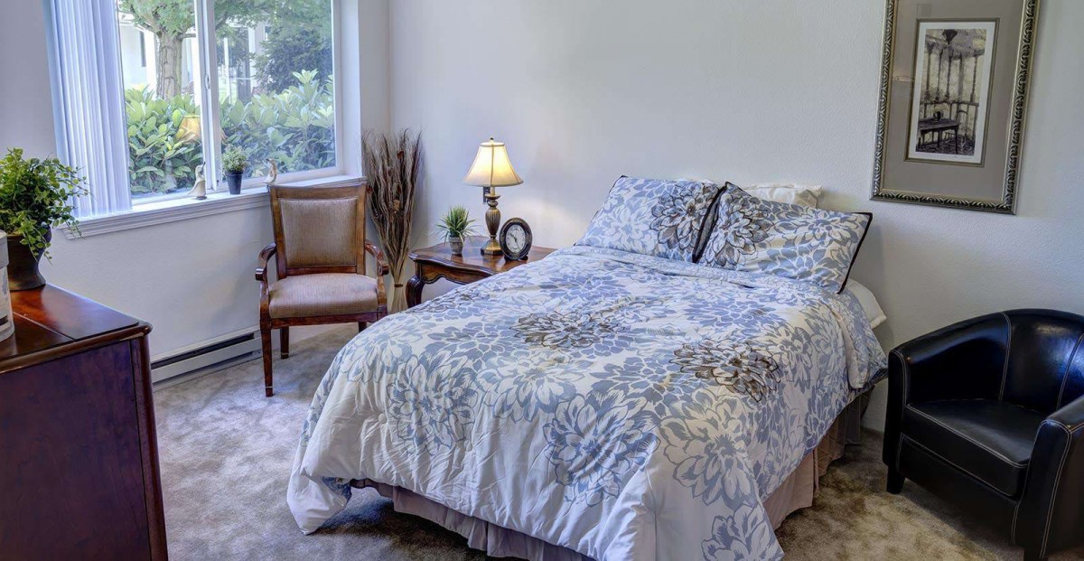 A cozy bedroom with a neatly made bed and elegant decor.