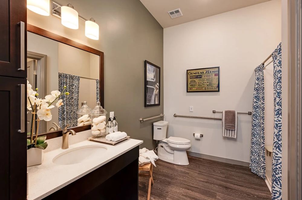 A modern bathroom with stylish decor, featuring a sink, toilet, and elegant lighting.