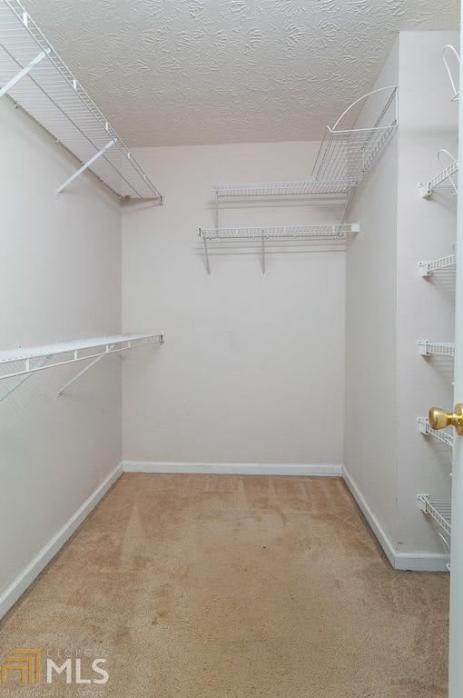 An empty walk-in closet with shelves and hanging rods, ready for organization.