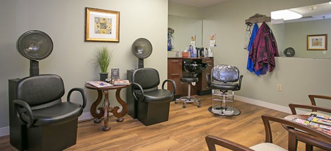 A cozy hair salon interior featuring salon chairs, mirrors, and styling equipment.