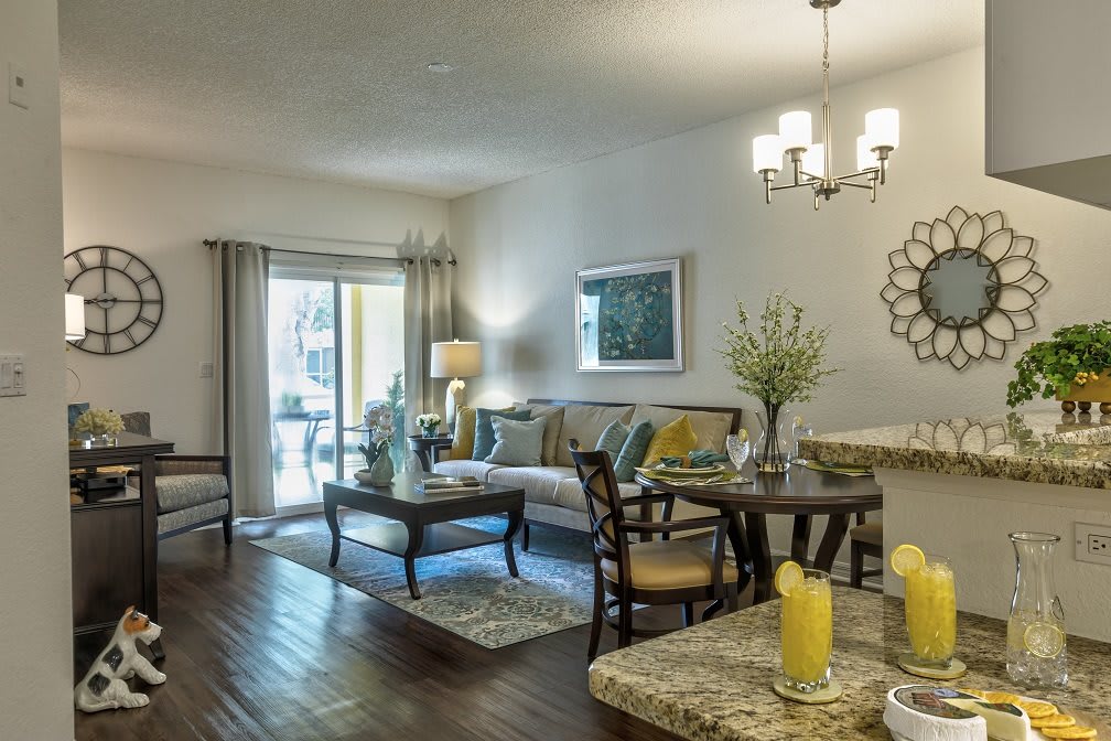 A modern living room with elegant furniture and decor, featuring a chandelier and hardwood floors.