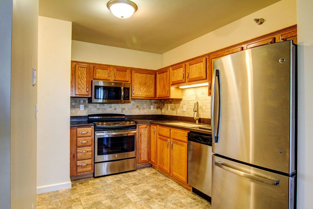 A modern kitchen with wooden cabinets and stainless steel appliances.