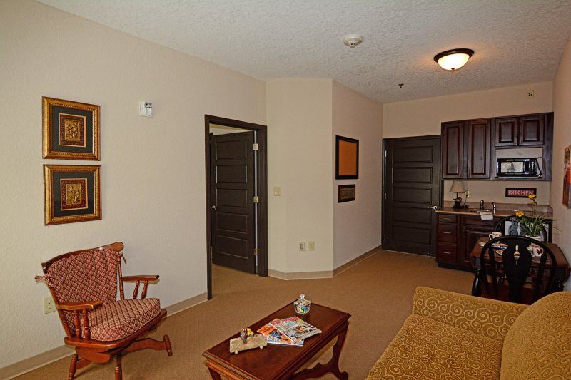 A cozy living space with a chair, table, and artwork on the walls.