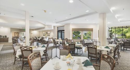 A spacious dining room with neatly arranged tables and chairs, featuring a bright and welcoming atmosphere.