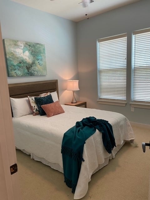 A cozy, well-decorated bedroom with a neatly made bed and soft lighting.