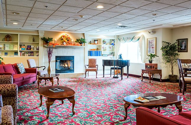 A cozy living room with a fireplace and piano, featuring elegant furniture and decor.