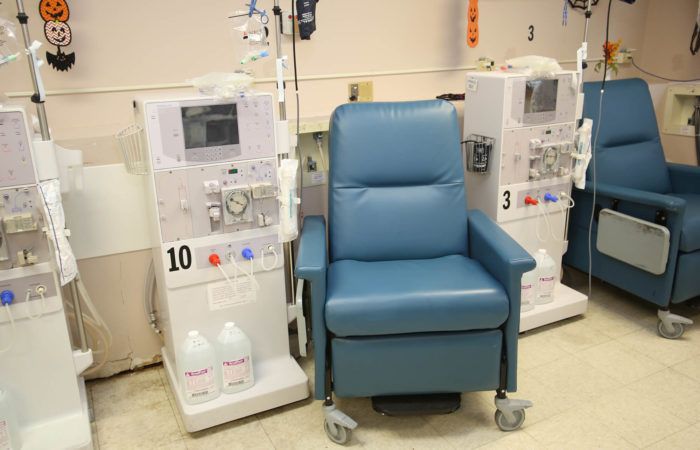 A hospital setting with a dialysis machine and a comfortable chair for patients.