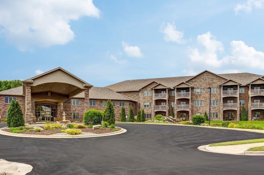 A multi-story residential building with landscaped surroundings and a spacious driveway.