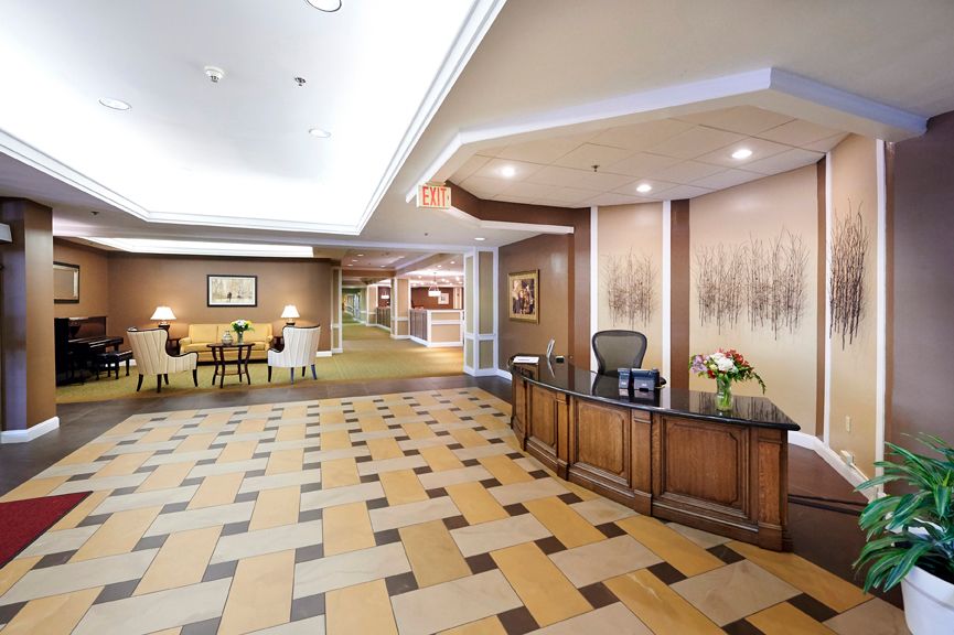 A hotel lobby with a reception desk and seating area.