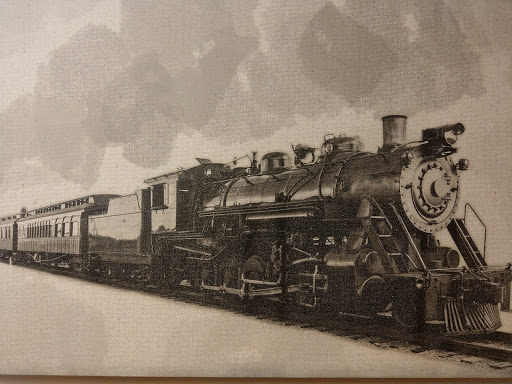 A classic steam locomotive on the tracks, captured in a vintage black and white style.