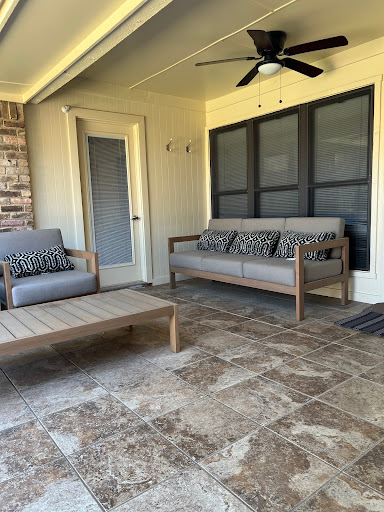 A cozy and stylish outdoor seating area featuring comfortable sofas and a coffee table.