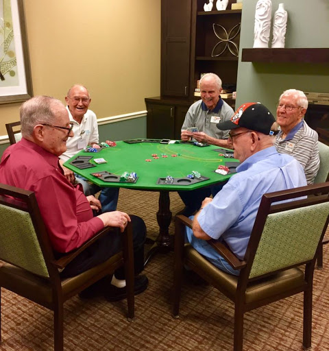 A group of seniors enjoying a friendly card game together.