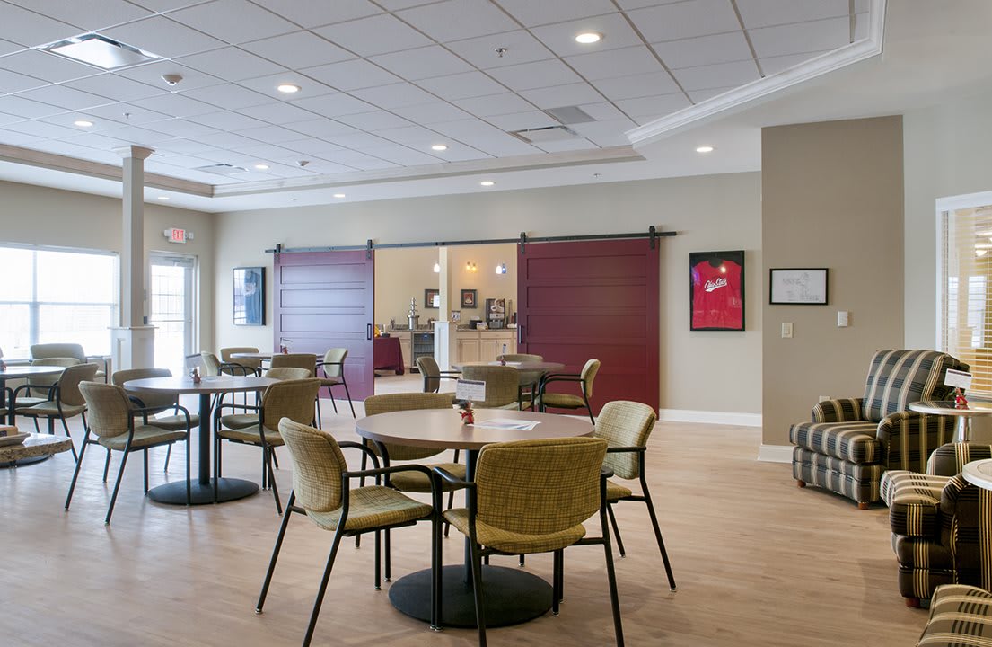 A modern cafe interior with tables and chairs arranged for dining.