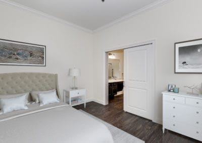 A modern, minimalist bedroom with white walls and elegant furniture.