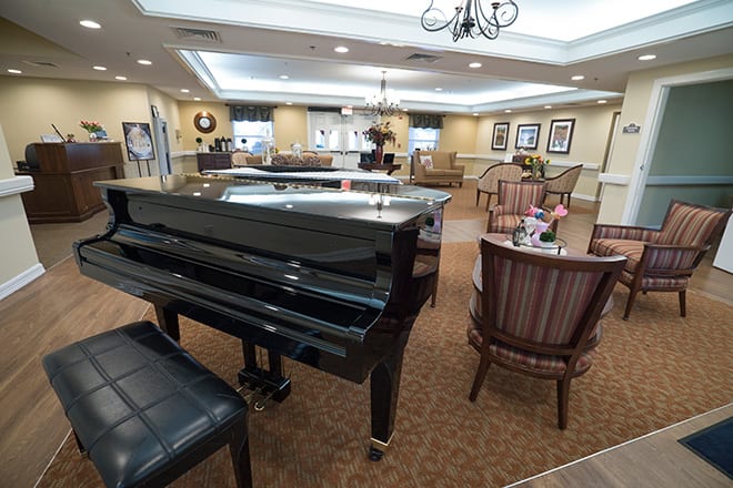 A cozy lobby featuring a grand piano with comfortable seating and elegant decor.
