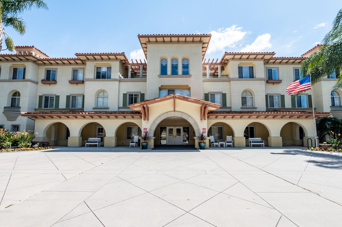 A three-story building with an arched entrance and Mediterranean-style architecture.