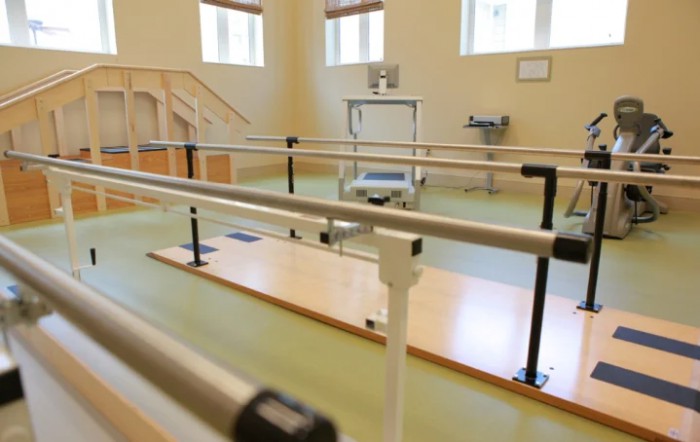 A physical therapy room equipped with parallel bars for rehabilitation exercises.