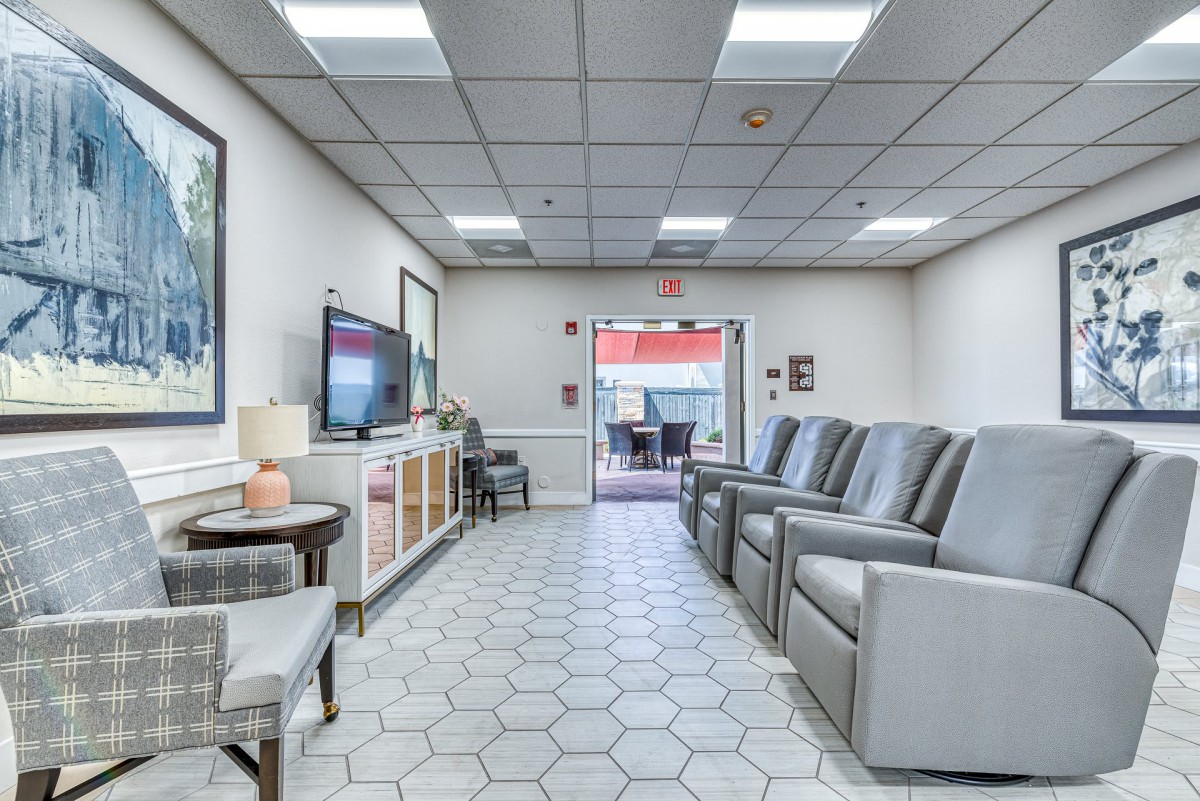 A spacious waiting room with comfortable seating and a television.
