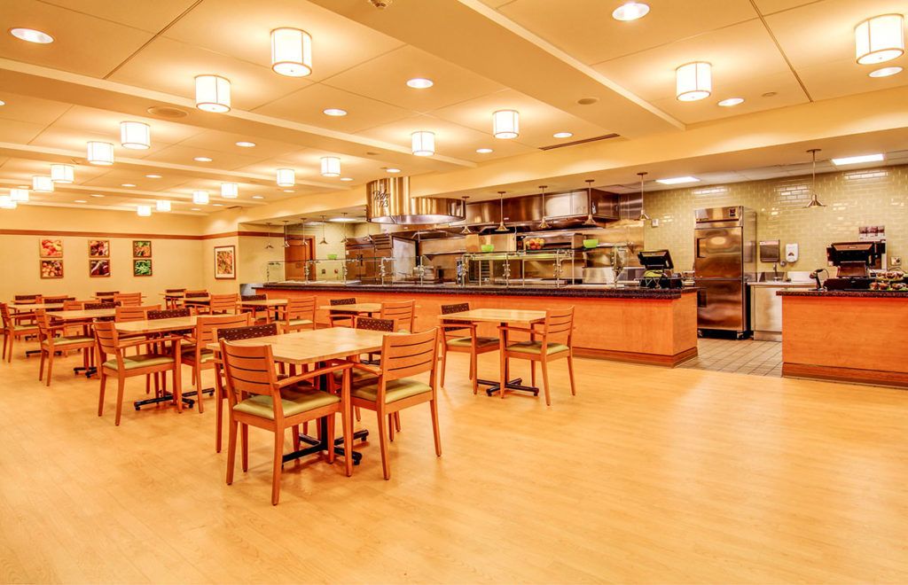 Spacious restaurant dining area with wooden furniture and warm lighting.