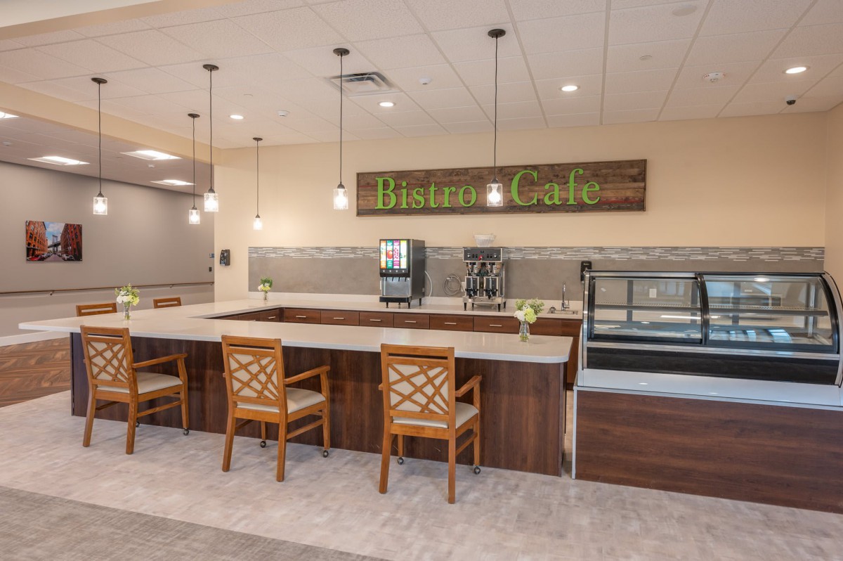 A modern bistro cafe interior with a seating counter and wooden chairs.