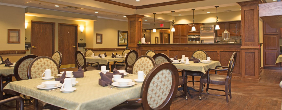 A cozy dining area with neatly arranged tables and chairs, featuring classic decor.