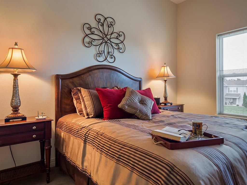 A cozy and well-decorated bedroom with a wooden bed, pillows, and ambient lighting.
