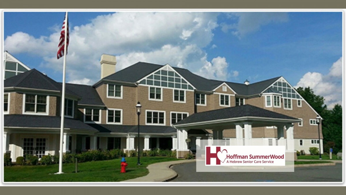 A modern healthcare facility with a welcoming entrance and a backdrop of a partly cloudy sky.