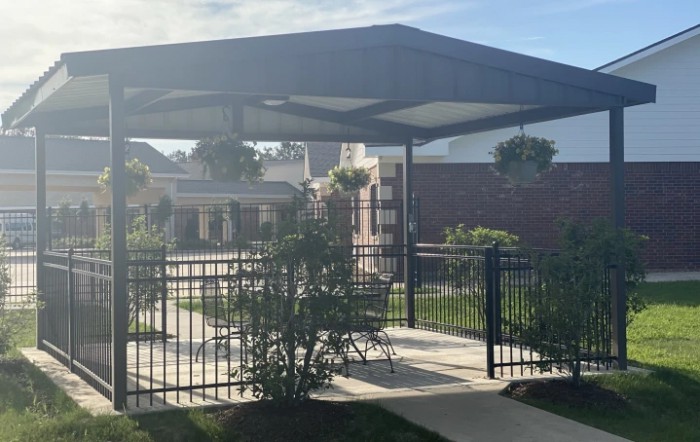 A sunny outdoor patio with a gazebo and hanging plants.