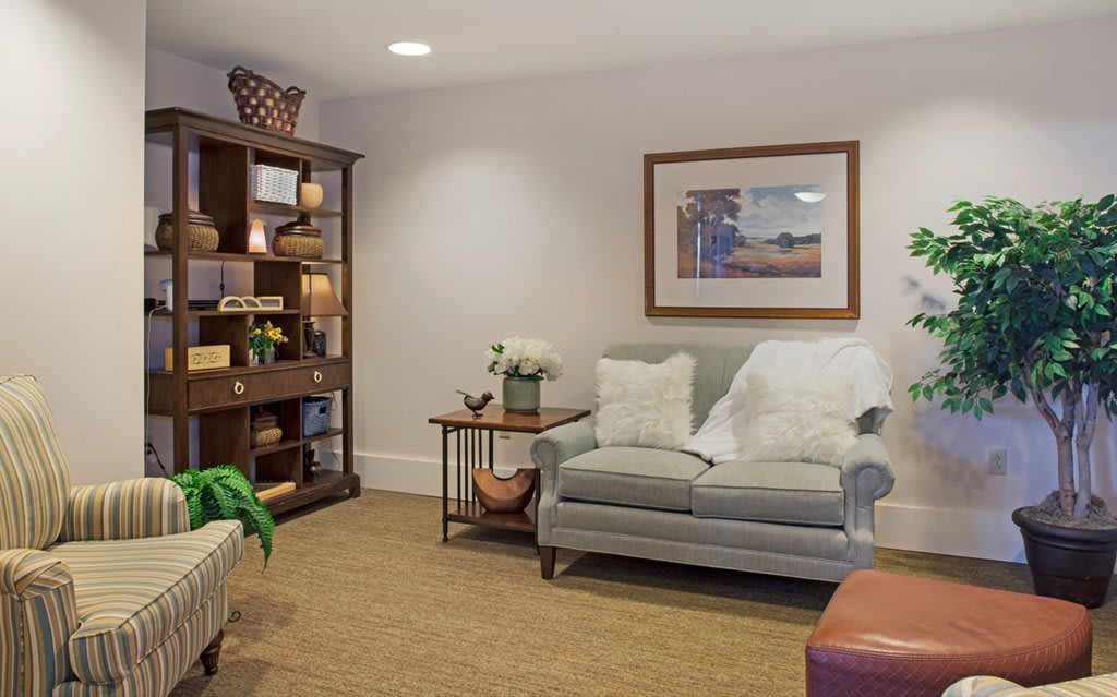 A cozy living room featuring a plush sofa, wooden shelving, and tasteful decor.