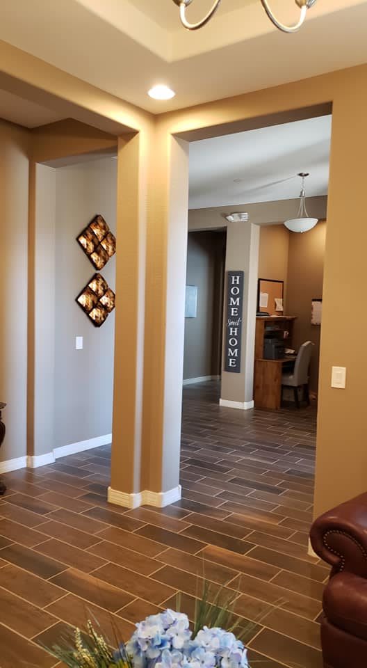 A warmly decorated hallway in a home with wooden flooring and wall art.