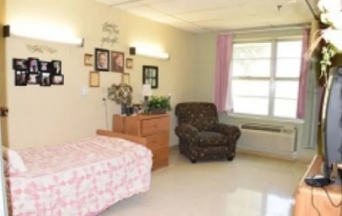 A cozy bedroom with a single bed, armchair, and decorative elements.